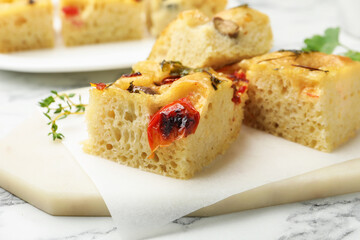 Pieces of delicious focaccia on white marble table, closeup