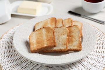 Slices of tasty toasted bread on white table, closeup