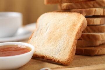 Slices of tasty toasted bread and jam on wooden table, closeup