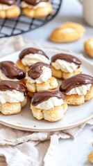 Savor a delectable &eacute;clair topped with rich chocolate glaze on a white plate, complemented by a steaming cup and saucer in a welcoming caf&eacute; setting.