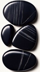 Delicately positioned smooth black stones on a white background create a peaceful and calming visual scene.