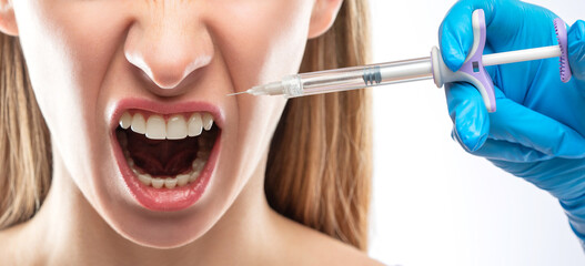 Cosmetologist does injections for lips augmentation and anti wrinkle in the nasolabial folds of a...