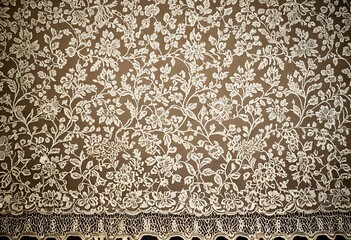 A close up of a white lace on a brown background.