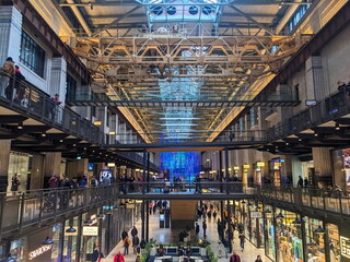 Shoppers explore the retail space within the repurposed turbine hall of the Battersea Power Station