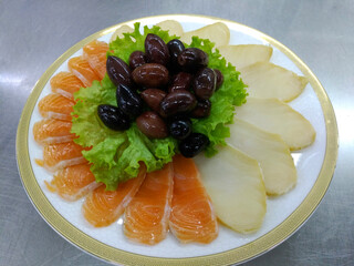 a large plate of sliced salmon and smoked butterfish fillet. Garnished with herbs, olives and lemon...