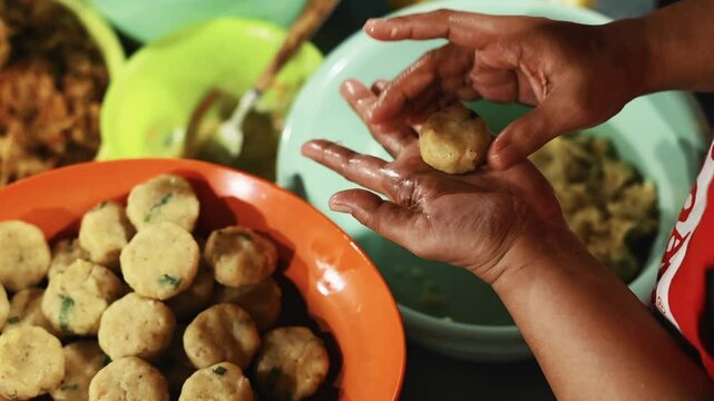 Balinese hands shaping traditional food in a local warung kitchen
