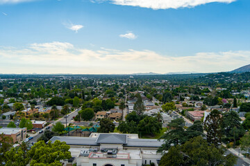 aerial shot of homes, restaurants and shops, Library Park,  the Monrovia Public Library and cars on...