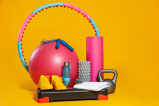 Many different fitness equipment on orange background