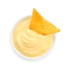 Tasty cheese dipping sauce in bowl and nacho chip isolated on white, top view