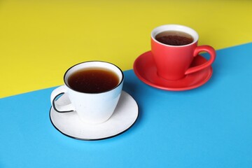 Cups with aromatic coffee drinks on color background, closeup