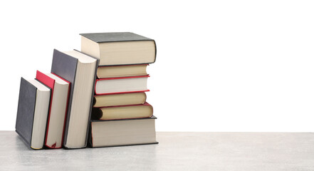 Old books on light grey table against white background