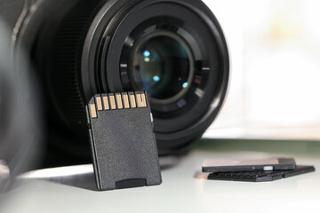 SD memory cards and photo camera on white table, closeup