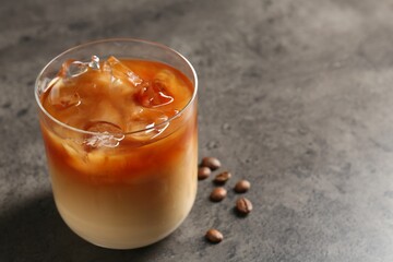 Tasty iced coffee and beans on grey table, closeup. Space for text