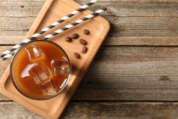 Tasty iced coffee and beans on wooden table, top view. Space for text