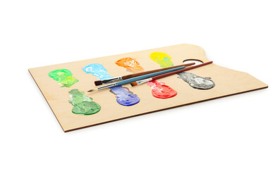 Wooden palette with paints and brushes isolated on white
