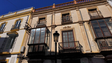 Traditional balconies and windows decorating building facades in Ronda, Spain