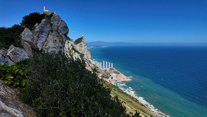 Gibraltar rock overlooking coastal city and Mediterranean sea on sunny day