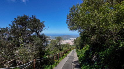 Scenic path descending towards Gibraltar city with Mediterranean Sea in background