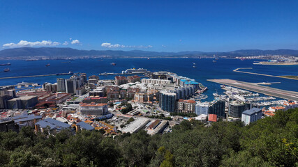 Obraz premium Gibraltar city and harbor embracing the Mediterranean sea under a clear blue sky