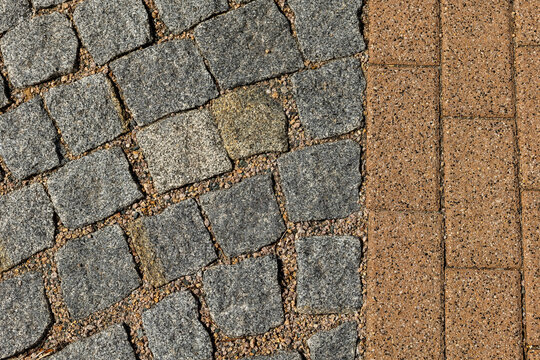 Beautiful contrast of textured stones and smooth pavement showcasing urban design in a sunny environment