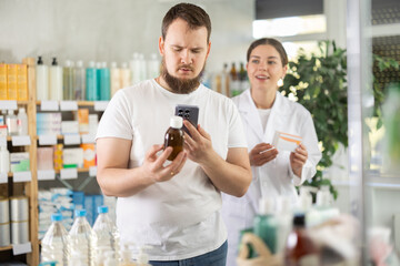 Man scans QR code on box cough syrup label. Female pharmacist offers various cough syrups