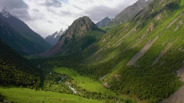 A stunning 4K drone shot showcasing the beauty of Ala Archa National Park in Kyrgyzstan, with clouds casting shadows on the green, lush mountains below.