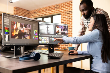 Multiethnic creative team brainstorming ideas and editing film content using computer monitors. Young filmmakers collaborating to edit movie footage with high quality production software.