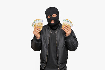 Criminal holding euro banknotes and smiling behind a balaclava