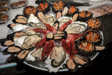 piatto di frutti di mare crudi servito in una pescheria