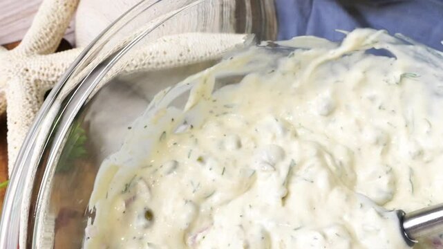 Making homemade tartar sauce for a seafood dinner. Tartar sauce with fresh ingredients that goes perfect with breaded fish.  Ingredients include mayonnaise, lemon, onions, herbs and capers.
