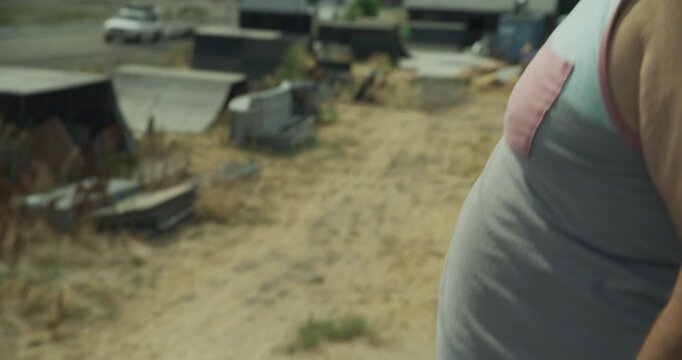 Dramatic shot of man with wheelbarrow standing on top of half pipe - slow motion panning shot to face