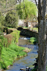 Hameau niché dans écrin de verdure avec ruisseau