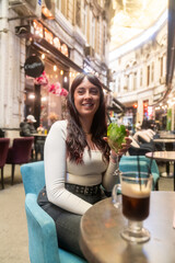 Young woman enjoying drinks at outdoor cafe in bucharest's passage macca-vilacrosse