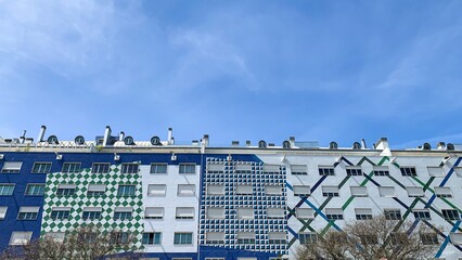 Colorful geometric building facade against blue sky, urban architecture art, contemporary design,...