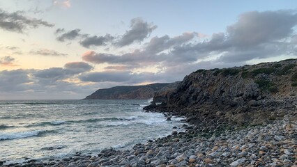 Rocky coastline during serene sunset, tranquil nature landscape, perfect for summer travel...