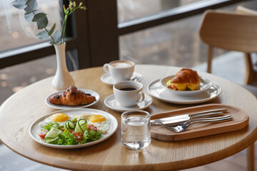 Delicious breakfast served on wooden table in cafe