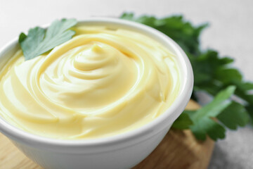 Delicious mayonnaise sauce with parsley in bowl on table, closeup