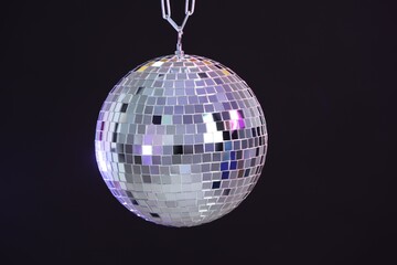 One shiny disco ball on dark background