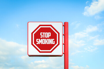Stop Smoking sign against blue sky with clouds