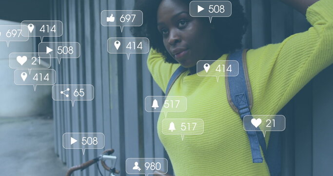 Image of social media notifications over african american woman standing in street with bike