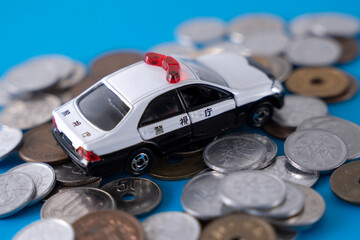 お金の上にパトカー 硬貨 現金