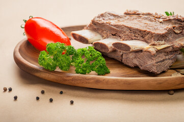 Juicy seasoned beef ribs with herbs and vegetables – close preparation shot.