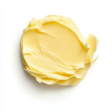 A smooth pat of butter glistens against a  white background, perfect for culinary inspiration.