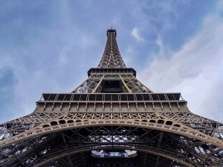 Dramatic Upward View of the Eiffel Tower Against a Moody Sky