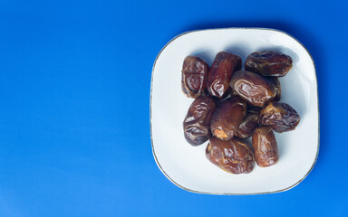 Close-up of fresh organic dates on a white plate, healthy food