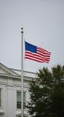 American flag waving over White House roof on cloudy day. Patriotic symbol for Memorial Day, Veterans Day, Independence Day. Remembrance and national pride concept