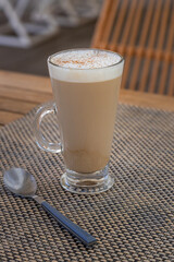 Cafe Latte with spoon and cinnamon on wooden table