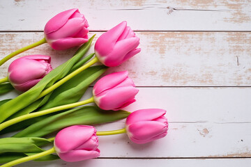 bunch of pink tulips on a wooden surface