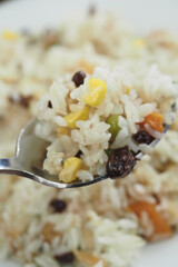 Colorful vegetable rice served on a silver spoon