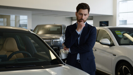 Caucasian man businessman touching car thinking client buyer automobile choosing choose rental...